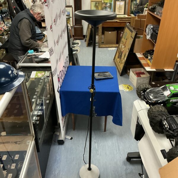 Black floor standing uplighter in a room setting.