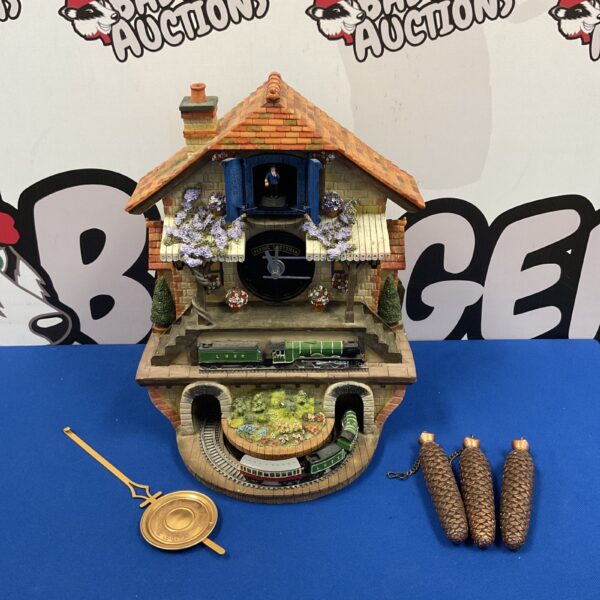 Detailed Bradford Exchange Flying Scotsman cuckoo clock with weights and pendulum.
