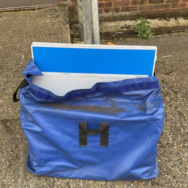 Blue carry bag containing folding display boards for presentations.