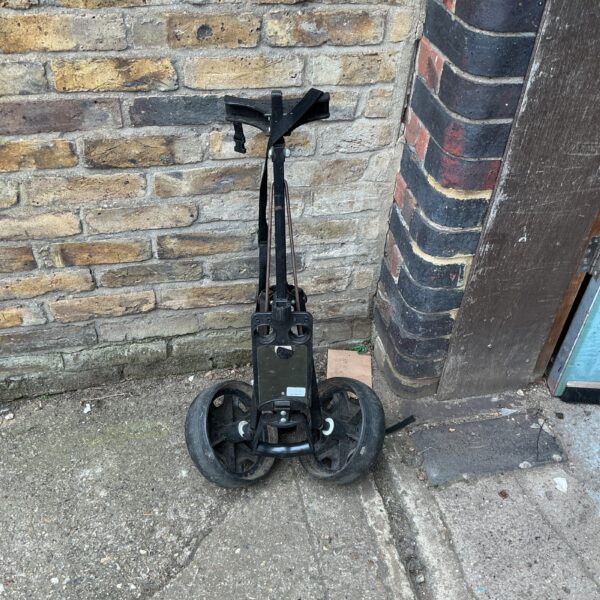 Side view of a folding golf cart with three wheels.