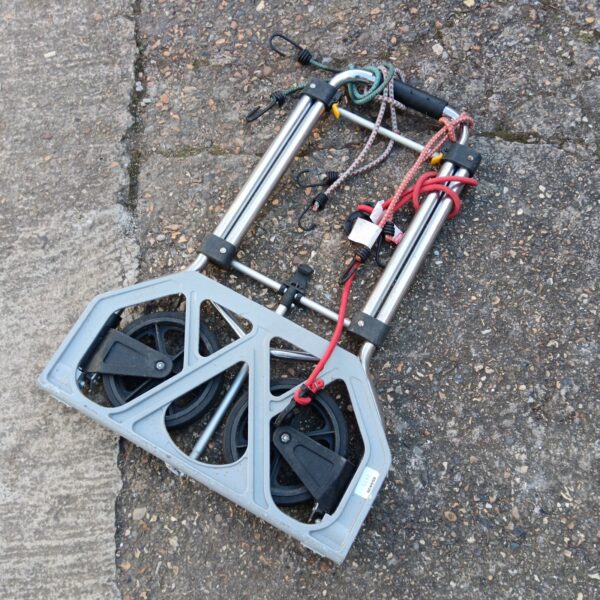 Collapsible folding sack barrow with wheels and bungee straps.