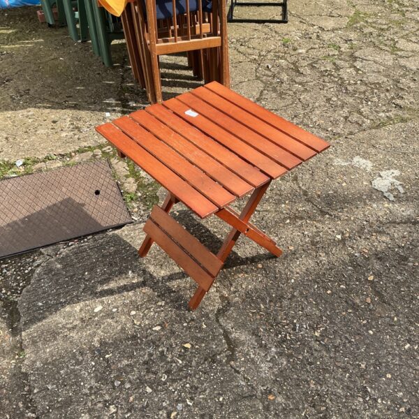 Small folding teak patio table, weathered wood, outdoor furniture.