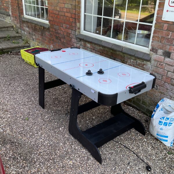 Full size air hockey table in a garden setting.