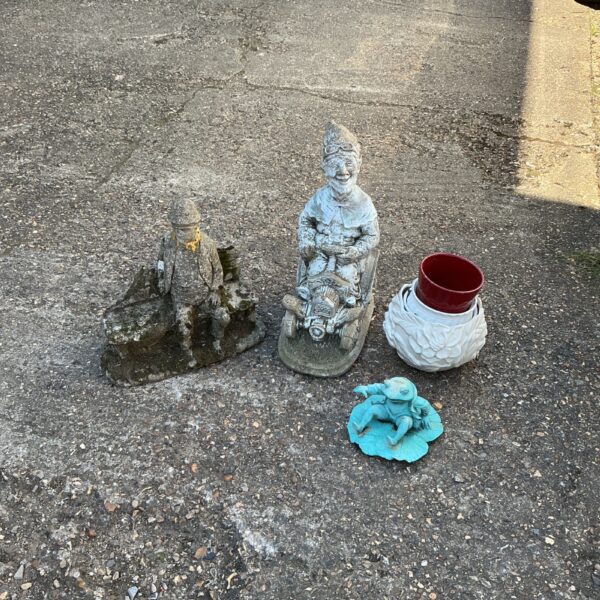 Collection of weathered garden ornaments and a decorative pot.