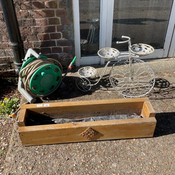 Vintage garden set with penny farthing, hose reel, and wooden trough planter.