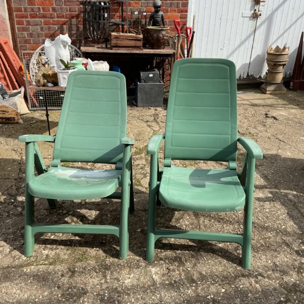 Pair of vintage plastic garden reclining chairs in a garden setting.
