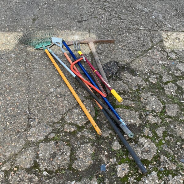 Vintage garden tool collection with a pick and other implements.