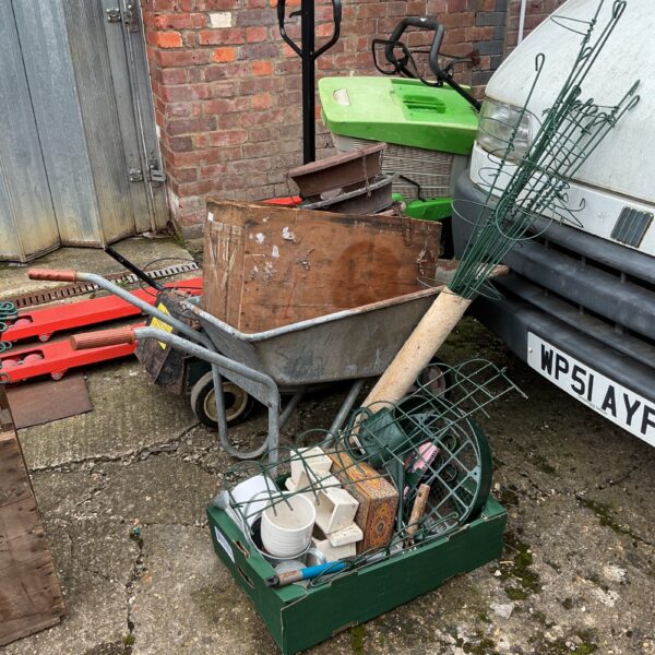 Garden tool lot featuring a wheelbarrow and various gardening implements.