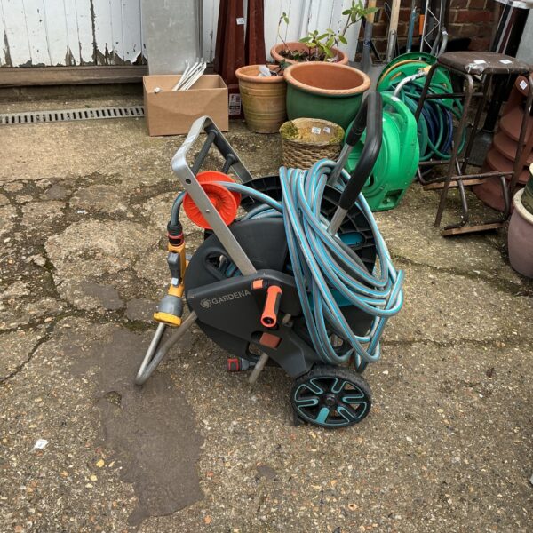 Blue and grey Gardena hose reel with attached garden hose.