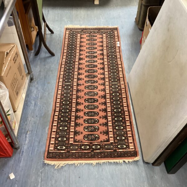 Vintage geometric runner rug with red and beige pattern.