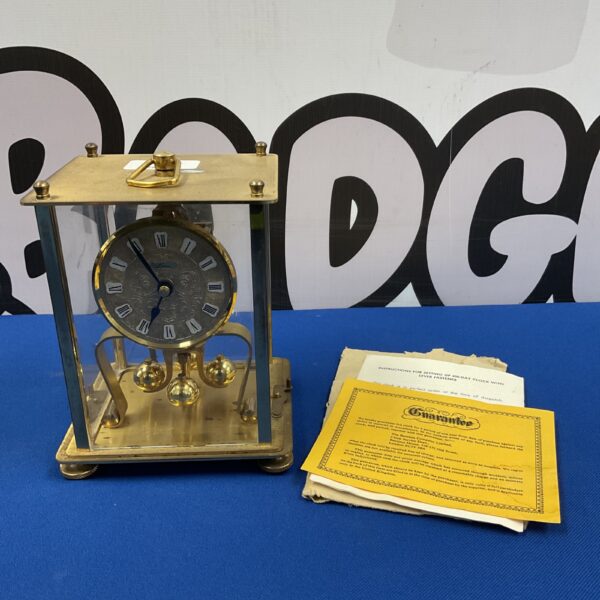 Vintage German anniversary clock with glass dome and brass frame.