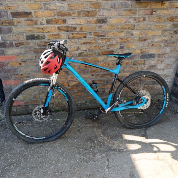 Blue Giant Fathom mountain bike with helmet, ready for trails.