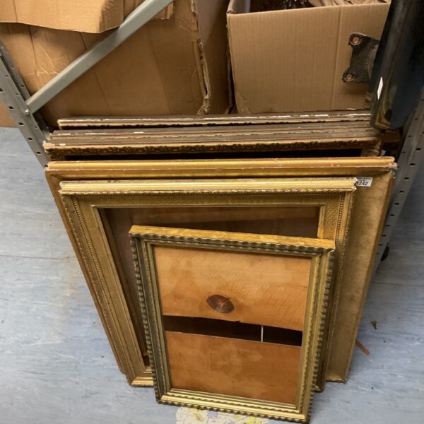 Stacked gilded picture frames for vintage wall decor.