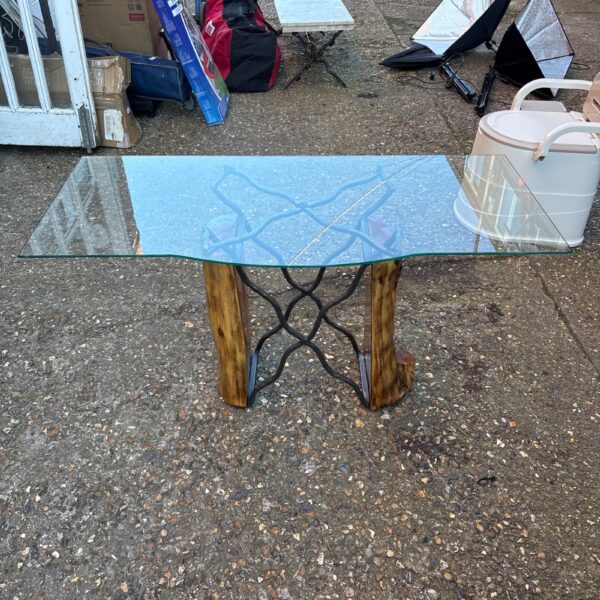 Handcrafted glass coffee table with wooden and cast iron base.