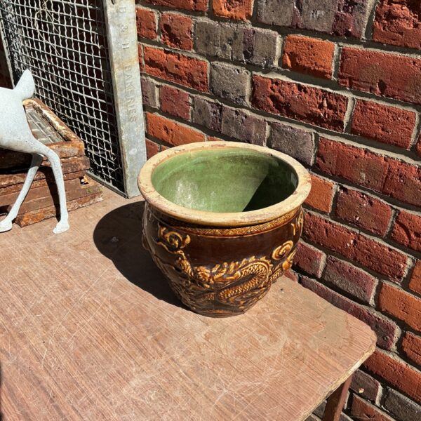 Vintage glazed garden pot with raised floral design.