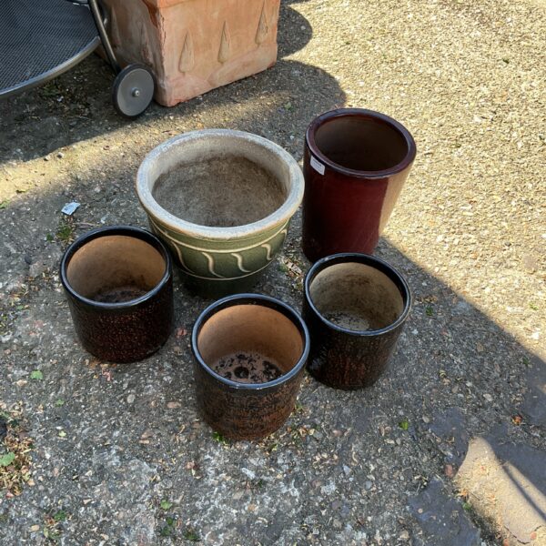 Collection of five glazed garden pots for outdoor planting.