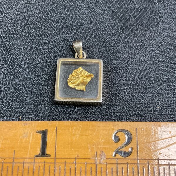 Close-up of a gold leaf pendant in clear resin.