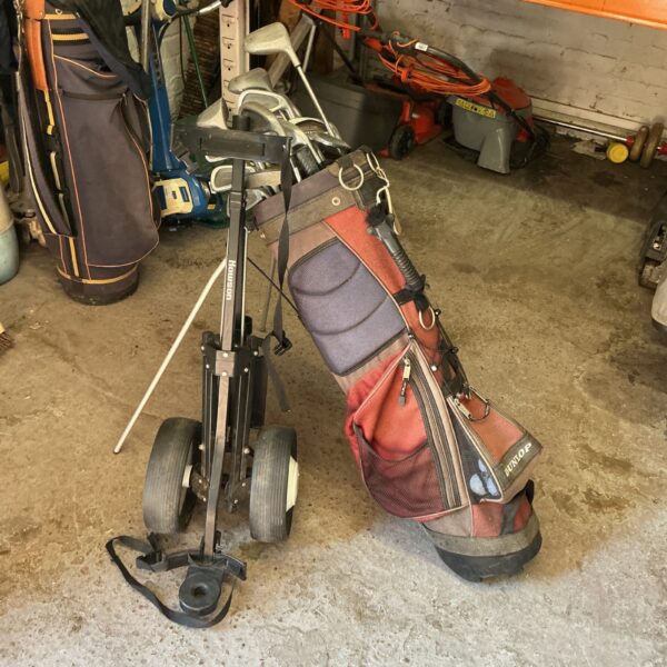 Golf clubs with bag and trolley, ready for the course.