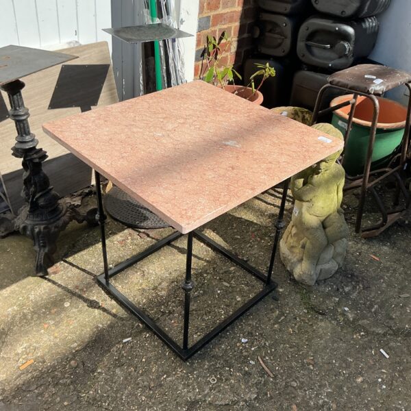 Reddish-brown granite garden table with black metal frame.