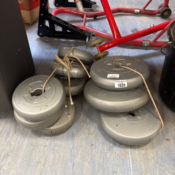 Grey weight plates stacked for strength training and fitness.