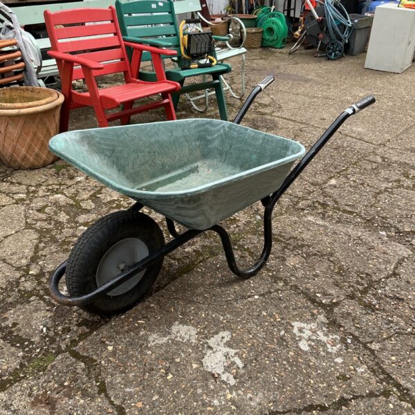 Vintage Haemerlin wheelbarrow in a garden setting.