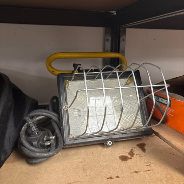 Used halogen work light with protective cage and handle.