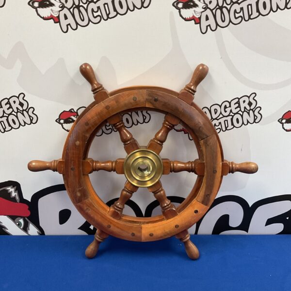 Classic hardwood ships wheel with brass centre for nautical decor.