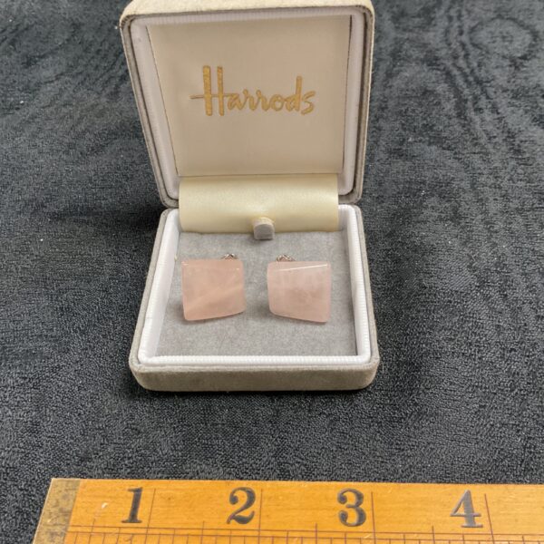 Vintage Harrods rose quartz clip-on earrings displayed on a cushion.