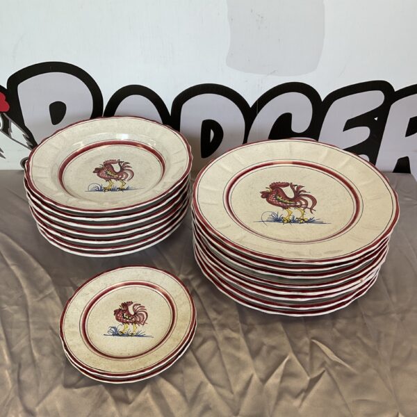 Lot of Harvey Nichols rooster plates stacked on a table.