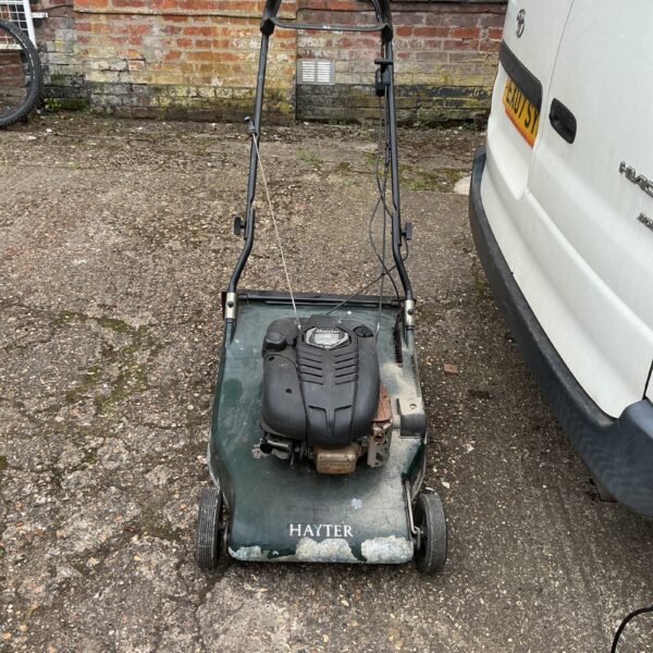 Vintage Hayter petrol lawnmower in a garden setting.