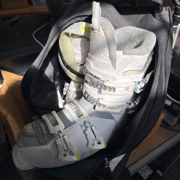 Side view of used Head Edge Next 65 ski boots in a bag.