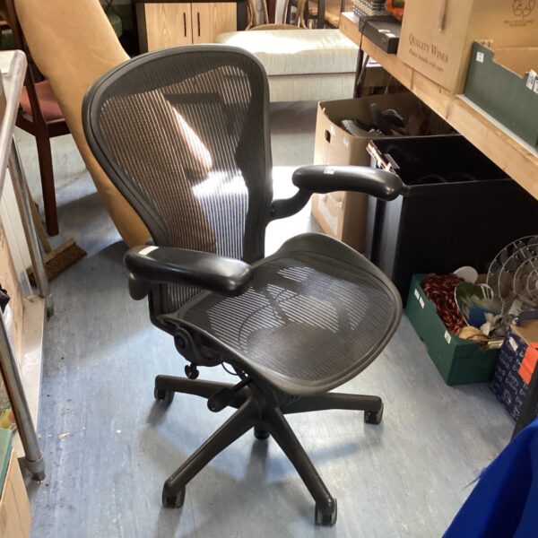 Black Herman Miller office chair with mesh back and adjustable arms.