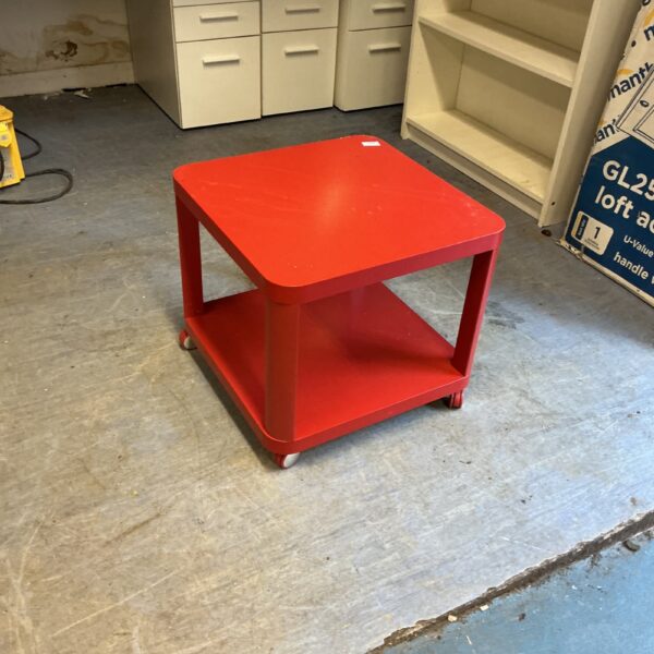 Vibrant red IKEA wheeled table for storage and display.