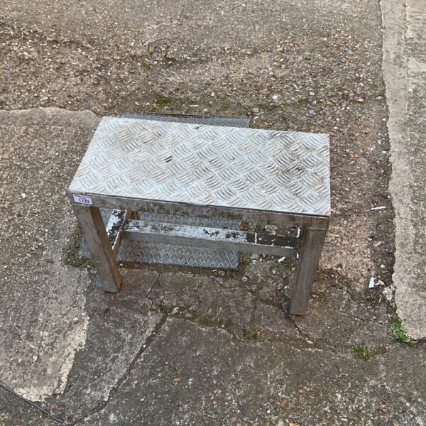 Vintage industrial metal step stool for workshop use.