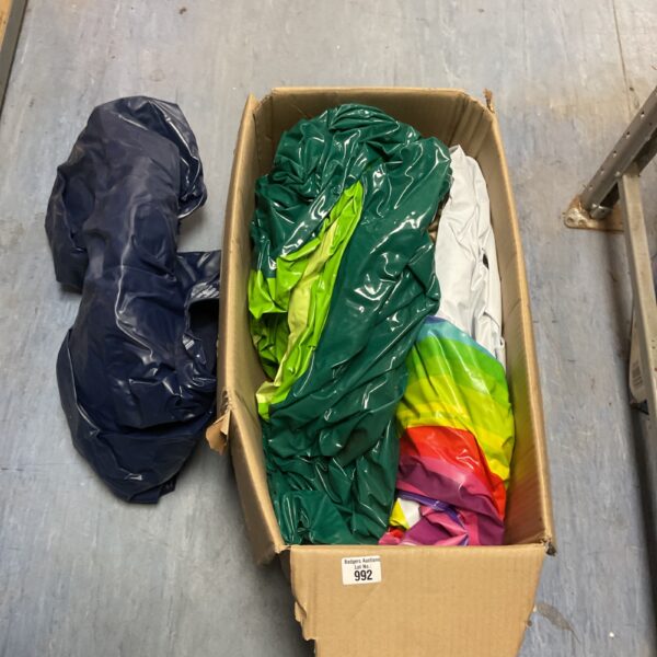 Deflated colourful inflatable mattress inside a cardboard box.