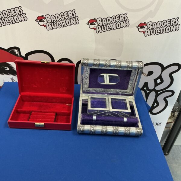 Vintage jewellery boxes with red and purple velvet linings on display.