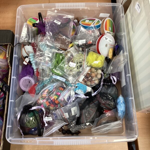 Assortment of beads, ribbon, and wire for jewellery making crafts.