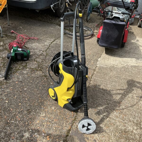 Karcher power washer in a garden setting, ideal for outdoor cleaning.