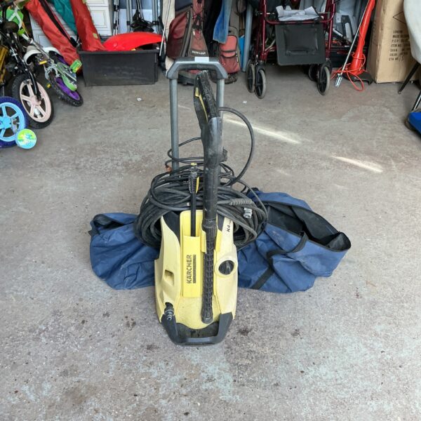 Karcher pressure washer with various cleaning attachments for outdoor use.