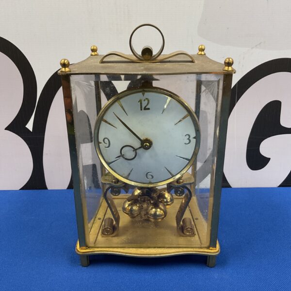 Vintage brass Kieninger anniversary clock on display.