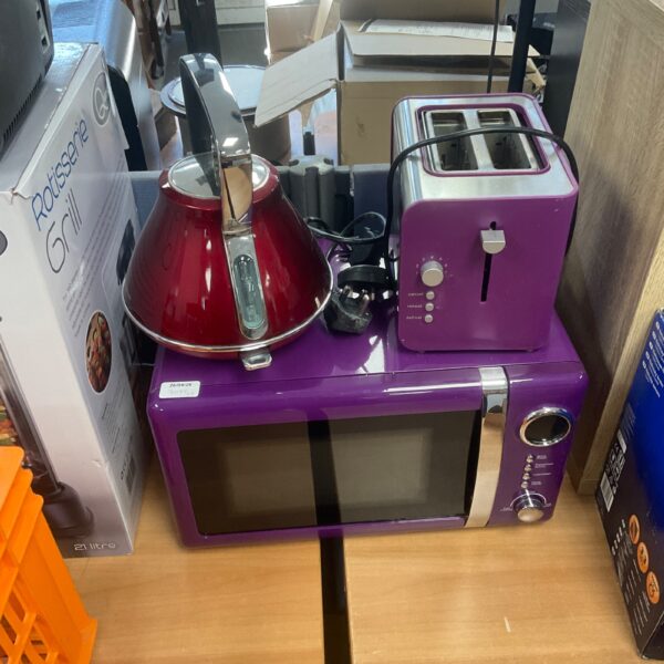Red kettle, toaster, and microwave in a kitchen appliance bundle.