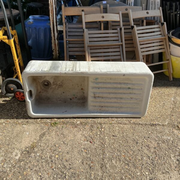 Large ceramic Belfast sink in a garden setting.