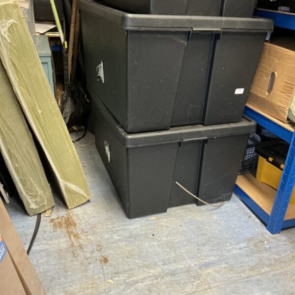 Stacked large plastic storage boxes for household organisation.