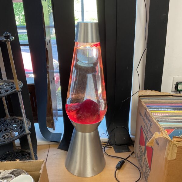 Large red lava lamp with silver base, vintage retro style.