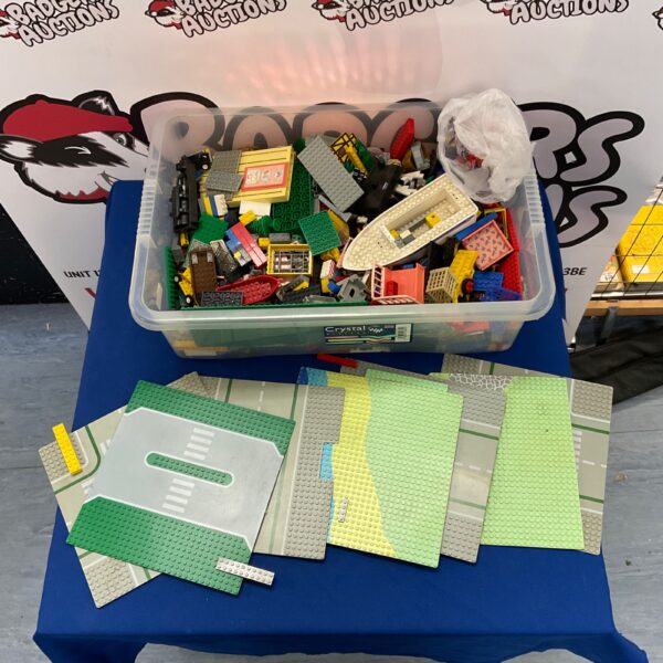 Assorted Lego pieces and building boards in a plastic storage box.