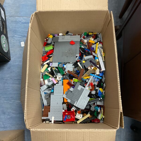 Assorted Lego bricks and pieces in a cardboard box.