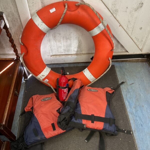 Two life jackets and a ring buoy for marine safety.