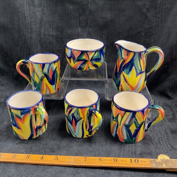 Linda Browne pottery set featuring colourful mugs and a cream jug.