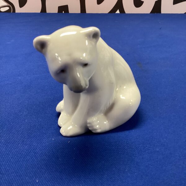 White Lladro porcelain polar bear sculpture on blue background.