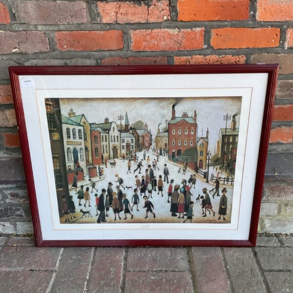 Framed LS Lowry print depicting a bustling village square scene.